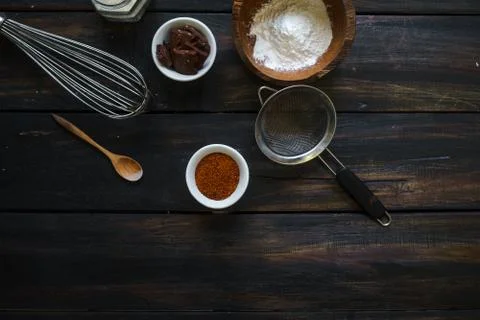Kitchen utensils are arranged randomly on a dark wooden table. Stock Photos