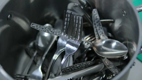 Kitchen utensils are thrown around carelessly clean spoons and forks in a Stock Footage 284434722