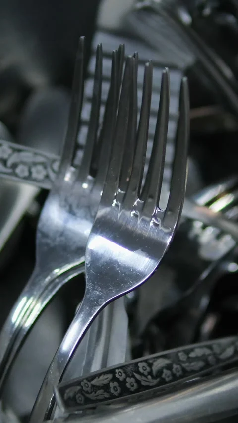 Kitchen utensils are thrown around carelessly clean spoons and forks in a Stock Footage 284439232