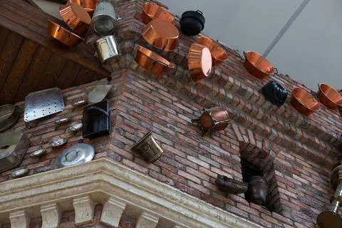 Kitchen utensils in brick wall of old building after being hit by catapult. M Stock Photos