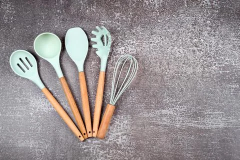 Kitchen utensils, home kitchen tools, mint rubber accessories on dark backgro Stock Photos