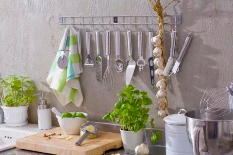 Kitchen utensils, string of garlic, basil, Parmesan etc. Stock Photos