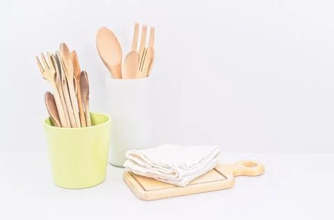 Kitchen ware and utensils on a table against white wall Stock Photos