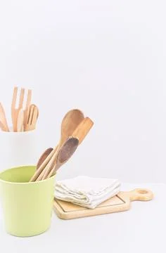 Kitchen ware and utensils on a table against white wall Stock Photos