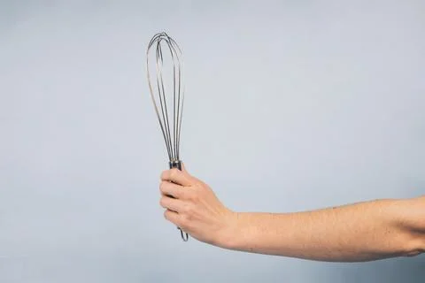 Kitchen-whisk-tool-in-hand   Stock Photos