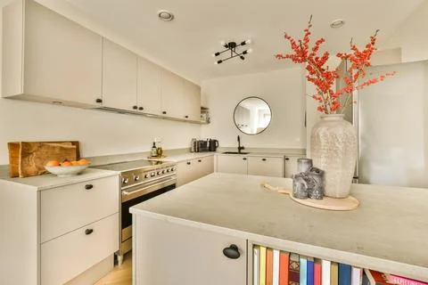 A kitchen with white cabinets and a marble counter top Stock Photos