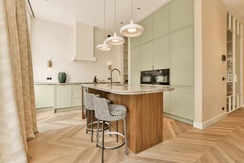 A kitchen with white cabinets and a marble counter top Stock Photos