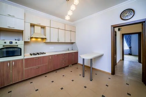 A kitchen with a white counter and a clock on the wall Stock Photos