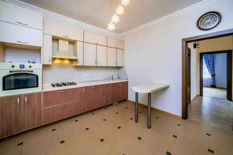 A kitchen with a white counter and a clock on the wall Stock Photos
