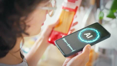 In the kitchen a woman communicates with an AI assistant on her smartphone h Stock Footage 343858027