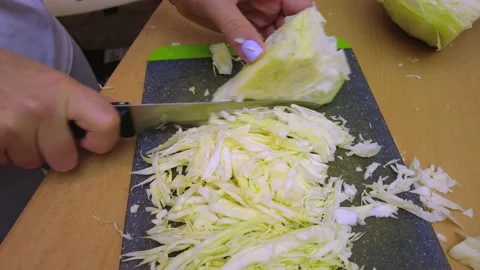 In the Kitchen, a Woman Cuts Cabbage on Cutting Boards Stock Footage