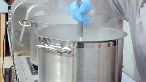 Kitchen worker prepares large volume broth, Catering staff actively cook Stock Photos