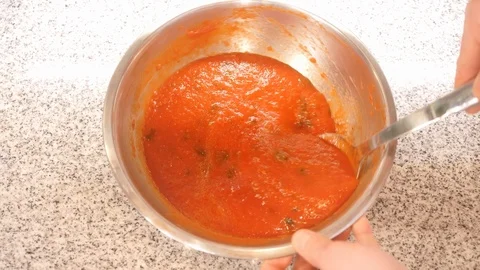 Kitchen worker stirs ketchup with herbal spice in metal bowl Stock Footage 127214923