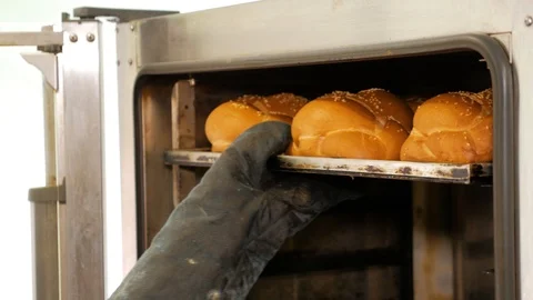 Kitchen worker takes out the bread from the oven in bakery. Stock Footage 108098977