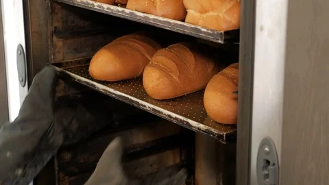 Kitchen worker takes out the bread from the oven in bakery. Stock Footage 109473186