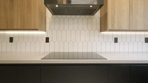 Kitchen working surface equipped with induction hob and illuminated by built-in Stock Footage 282256517