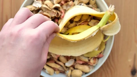 Kitchen Zero waste. Hand Holding Banana peel Over Food Scraps Video stock 333209107
