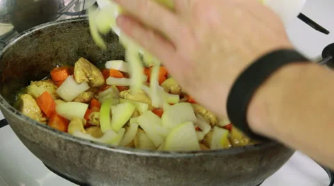 Kitchener adding onion in kettle with simmering ingredients of pilaf Stock Footage 32597391