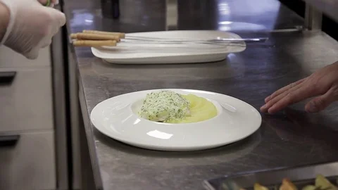 Kitchener decorates dish of potatoes standing in kitchen on table Stock Footage 76100165