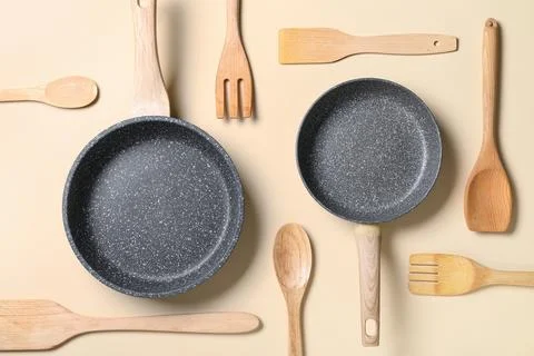 Kitchenware and cooking utensils flat lay with two frying pans and wooden spo Stock Photos