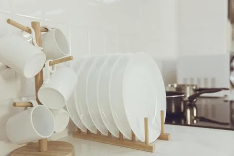 Kitchenware ceramic dishware managed row of clean new dish and cups Kitchen. Stock Photos