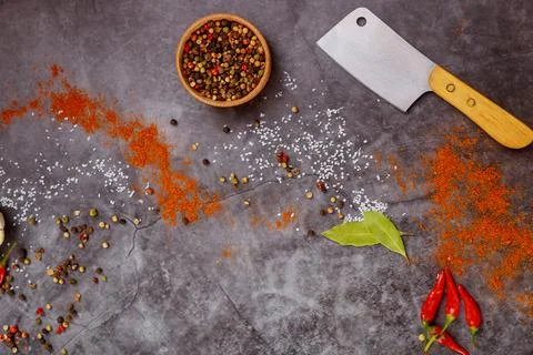 Kitchenware cleaver and spices on dark background. Stock Photos