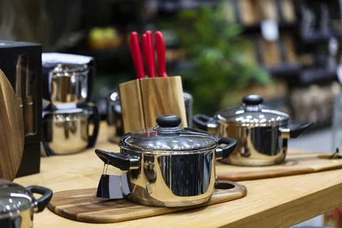 Kitchenware, cookware set on wood table. Beautiful modern new pans. Interior  Foto stock