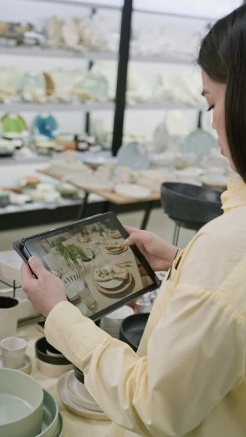 Kitchenware store Assistant Scrolling through Product Photos on Tablet Stock Footage 321776224