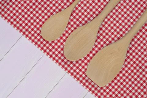 Kitchenware on white and red towel over wooden kitchen table. View from above Stock Photos