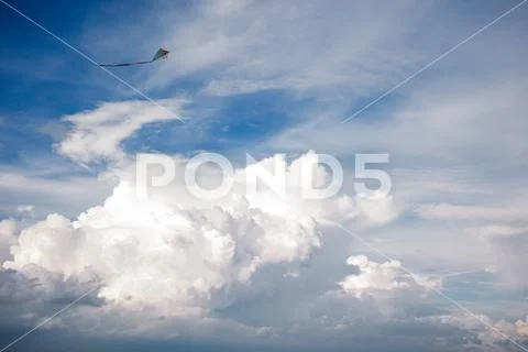 Kite and Cumulus clouds and sun in the sky Stock Photos