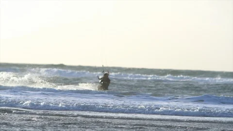 Kite boarder riding the waves at sunset. 스톡 동영상 88373573