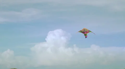 A kite flies in the sky with puffy clouds in background Stock Footage 37826932
