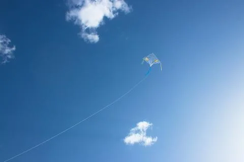 A kite floating in the sky. Blue sky and cloud in the background. Stock Photos