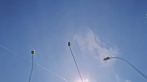 Kite flying high in the bright blue sky with wispy clouds and sun flares Stock Footage 342796875
