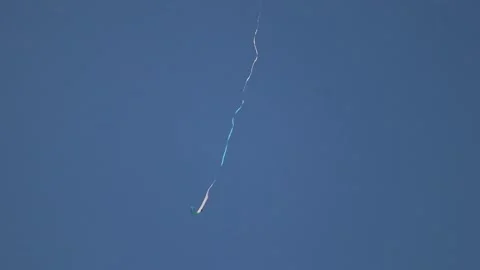 Kite Flying High in a Clear Blue Sky with Long Trailing Tail Stockbeeldmateriaal 313062173