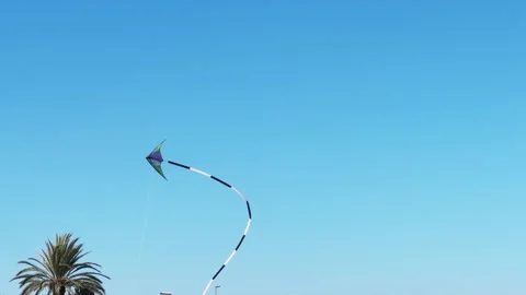 Kite flying in the wind close-up. Flying kite against the blue sky on a sunny Stock Footage 334315704