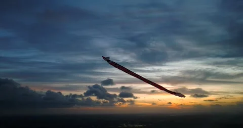 Kite soaring in the evening sky, among clouds at sunset Stock Footage 274523546