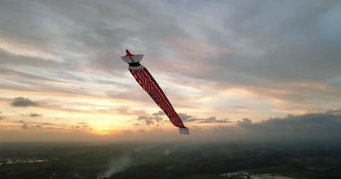 Kite soaring in the evening sky, among clouds at sunset Видео 274523844