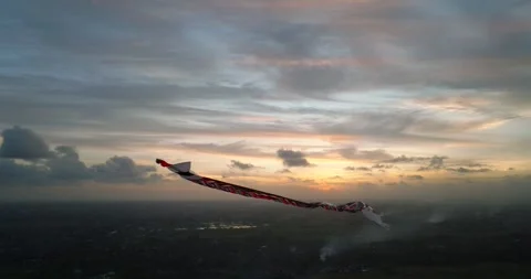 Kite soaring in the evening sky, among clouds at sunset Stock Footage 276253877