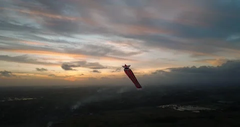 Kite soaring in the evening sky, among clouds at sunset Stock Footage 276253890