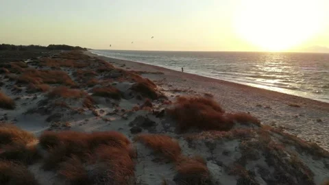 Kite Surfer in back during sunset with beach dunes in foregournd Stock Footage 138086251