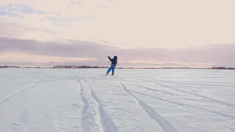 Kite surfer being pulled by his kite across the snow Stock Footage 103572481