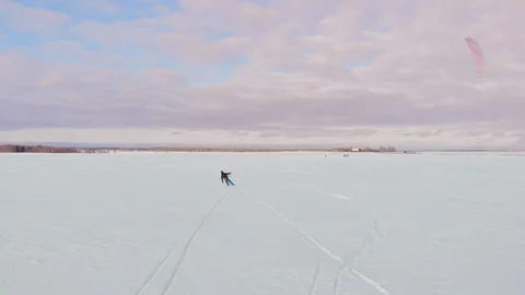 Kite surfer being pulled by his kite across the snow Video stock 103576986