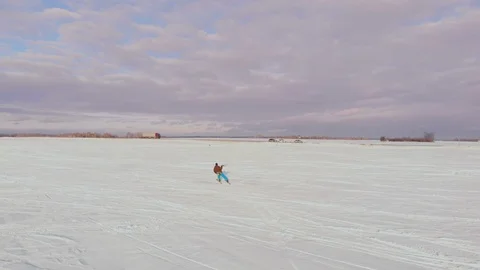 Kite surfer being pulled by his kite across the snow Video stock 103984994
