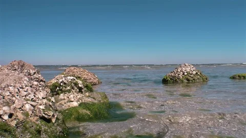 Kite Surfer Crosses Frame at Rocky Beach, 4K Stock Footage 70357607