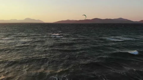Kite surfer during sunset on windy day with island in background Vídeo Stock 138086560
