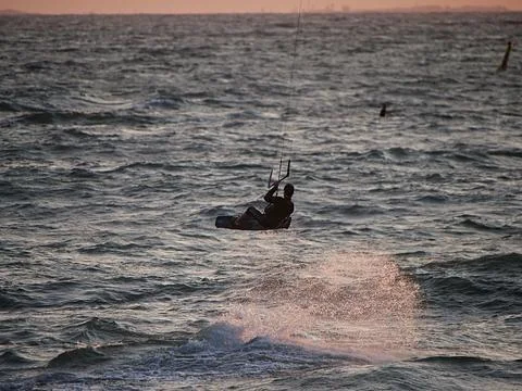 Kite surfer getting air at sunset Stock Photos