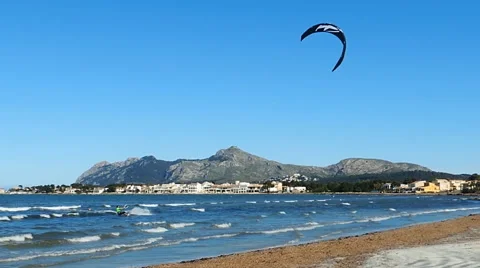 Kite surfer glides over the blue waters of Pollenca Bay Stock Footage 49927108