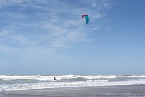 Kite surfer navigating the waves under a clear blue sky Stock Photos
