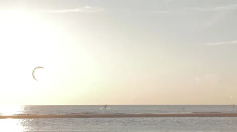 Kite surfer surfing at ocean at sunset wide shot pan Stock Footage 44391794